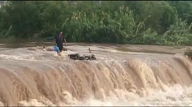 Over-confident motorcyclist loses his bike trying to ford flooded Indian river