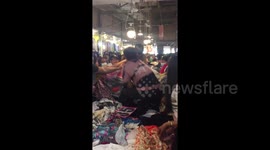 Filipino shoppers go berserk and wrestle with each other to grab used designer dresses on market stall
