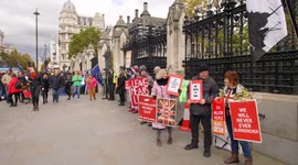 Pedestrians pass Brexiteers outside Parliament