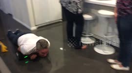 Dad uses kids' hover board to race around house lying down