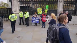 Zoom out of slow motion crowds passing Brexit protestors