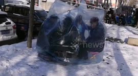 Poker players take cover from snow in homemade plastic shelter in China