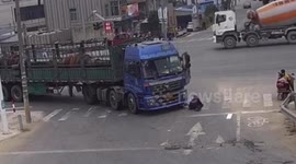 Chinese biker luckily escapes serious injury after being knocked over and dragged by truck