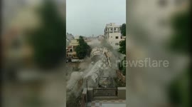 Footage shows controlled demolition of defunct water tank crushing house in western India