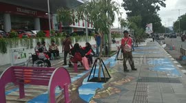 Three-dimensional sidewalk painting entrances pedestrians in Indonesia