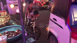 Kids Ride Through Evening Traffic In Cambodia