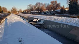 Truck driver loses control on icy Colorado road and falls in a canal