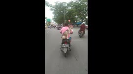 a dog and the owner are riding motorbikes on the Padang city road