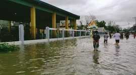 Residents wade through flooded streets after Typhoon Kammuri lashed the Philippines