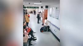 Father-to-be squats down to become 'human chair' for pregnant wife in Chinese hospital