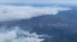 Aerial view from plane window shows wall of smoke from Australia's bushfires at 25,000 feet