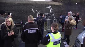 Police pose for pictures as they guard new Banksy artwork in Birmingham highlighting homelessness at Christmas