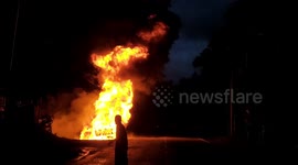 Burning vehicle left on side of forest road in western Indonesia