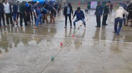 Weird party game in Vietnam sees people knocking over cans using dangling bananas tied to them
