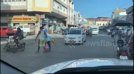 Kindhearted driver hold up traffic to help old lady cross the road