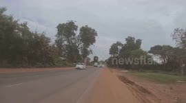 Reckless motorists drive in the wrong lane forcing motorcycle rider into dirt track in Cambodia