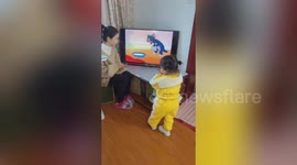 Chinese woman interacts with 'Tom and Jerry' cartoon on TV to entertain her daughter