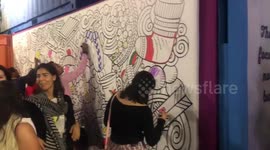Youth paint a large picture about christmas on the wall