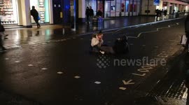 Weird scene as couple sit in middle of road in central London, holding up traffic
