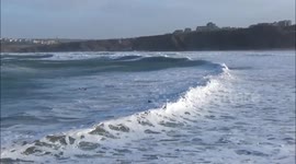 Surfers brave icy waters and storm waves in Cornwall, England