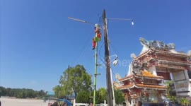 Circus acrobats help retrieve reporter's drone from the top of utility pole