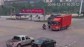 Chinese biker avoids serious injury after being sandwiched by two trucks