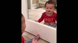 Sweet baby discovers a cutie in the mirror—himself