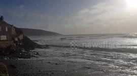 Wind and rain showers high waves and people still letting there dogs in the sea