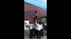 The man used his head to lift a large drum and a man playing the trumpet sat on the drum