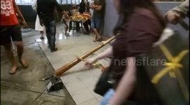Man uses a long wooden pipe to create a unique sound