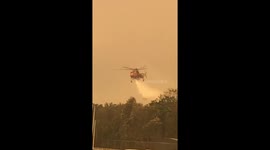 Water-dropping helicopter waters down NSW fires as it continues to grow near Batemans Bay evacuation center