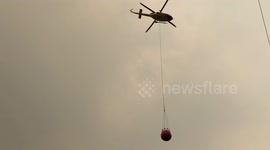 Waterbomber helicopter refills water from a private dam to fight bushfires in Nowra, NSW, Australia