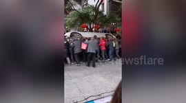 Dozens of people push car away from fire engine access after residential building catches fire in China