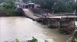 Residents in Indonesia forced to use collapsed bridge after heavy rain wreaks havoc