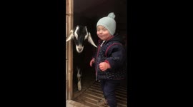 Adorable toddler tries to kiss her baby goat