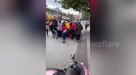 Dozens of passersby rush to lift car to rescue biker trapped underneath in China