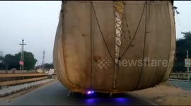 Massively overloaded tractors take up two lanes on north Indian highway