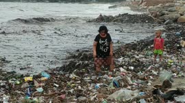 Families in Indonesia search through heaps of rubbish washed up on beach for valuables