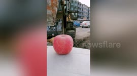 Chinese man manages to thread a needle stuck in apple while driving an excavator