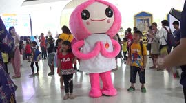 Children pose with two cartoon characters during Children's day celebrations at a temple in Thailand.
