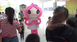 Children pose with a cartoon character during Children's Day celebrations, at a Buddhist temple in Thailand.