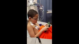 A boy with kidney disease still has a smile on, all thanks to his stepfather, they're both playing game on their devices
