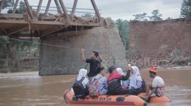 Indonesian locals use rubber rafts to cross surging river after floods sweep away bridge