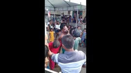 Party-goers try to pull coins from coconut in bizarre game
