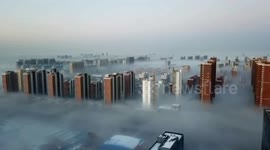 Aerial footage showcases high-rise buildings poking out from blanket of thick fog in China