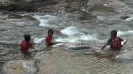Children play in rocky waterfall after drought lowered the water levels