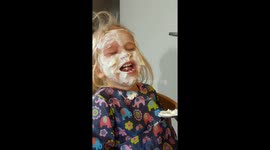 Two-year-old can't contain her laughter as dad paints her face in yoghurt