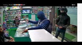 Terrifying moment armed robbers fire warning shot while threatening drug store cashier