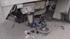 Unsuspecting Chinese biker luckily survives after being run over by truck