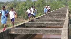 Children risk their lives crossing narrow canal bridge to school in eastern India
